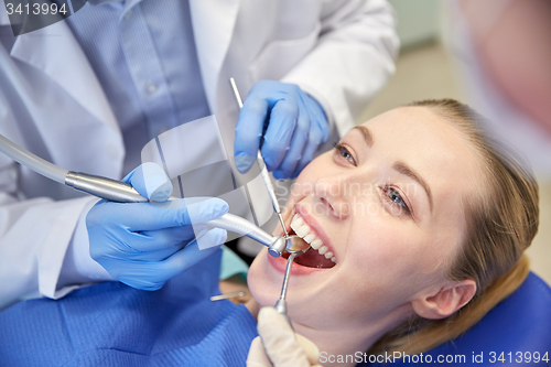 Image of close up of dentist treating female patient teeth