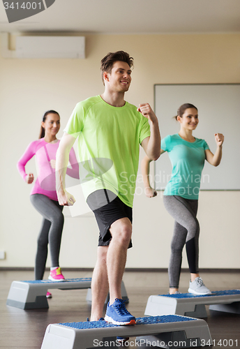 Image of group of people working out with steppers in gym