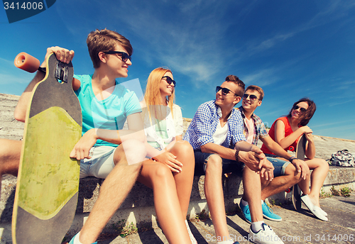 Image of group of smiling friends sitting on city street