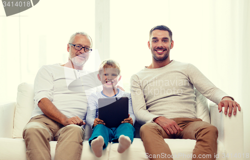 Image of smiling family with tablet pc at home