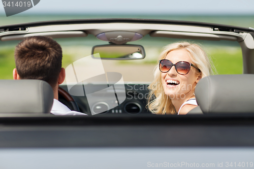 Image of happy man and woman driving in cabriolet car