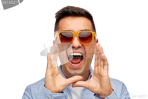 Image of face of angry shouting man in shirt and sunglasses