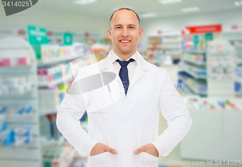 Image of smiling male pharmacist in white coat at drugstore