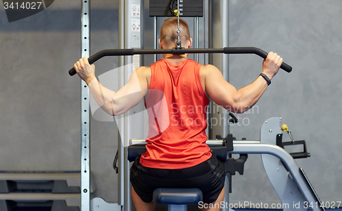 Image of man flexing muscles on cable machine gym