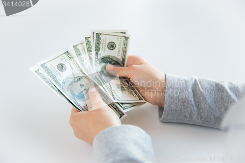 Image of close up of woman hands counting us dollar money