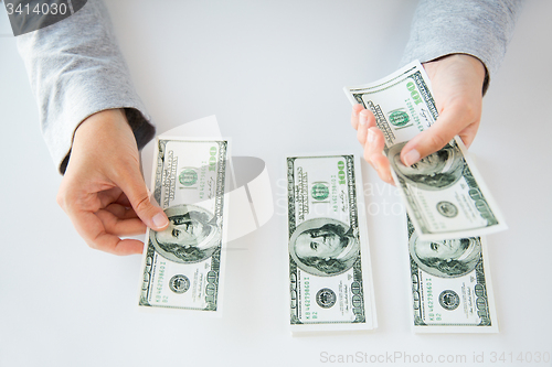 Image of close up of woman hands counting us dollar money