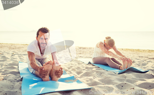 Image of couple making yoga exercises outdoors
