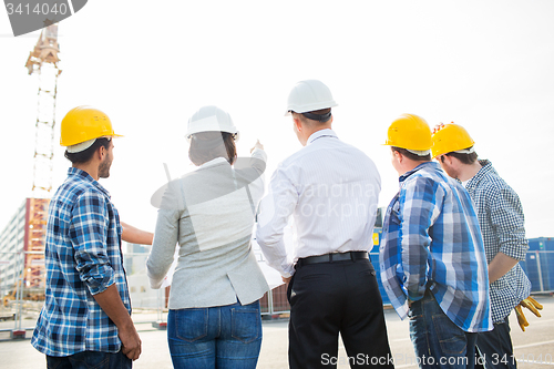 Image of group of builders and architects at building site