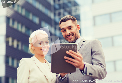 Image of smiling businessmen with tablet pc outdoors