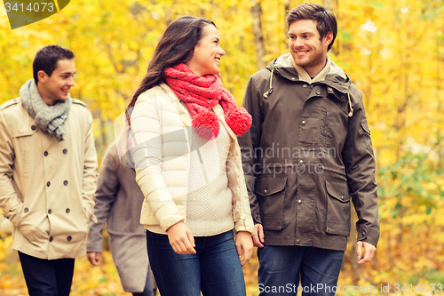 Image of group of smiling men and women in autumn park