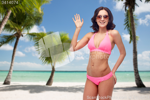 Image of happy woman in sunglasses and bikini on beach