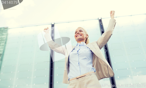 Image of young smiling businesswoman over office building