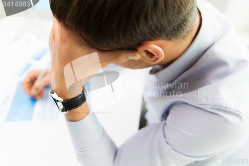 Image of close up of businessman with laptop and papers