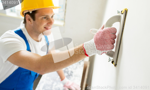 Image of close up of builder working with grinding tool