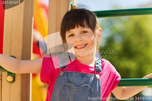 Image of happy little girl climbing on children playground