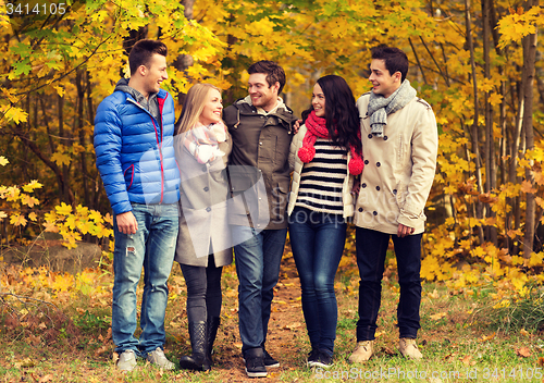 Image of group of smiling men and women in autumn park