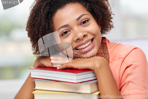 Image of happy african student girl with books at home