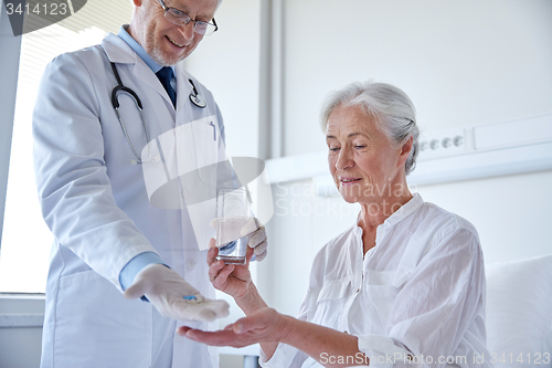 Image of doctor giving medicine to senior woman at hospital