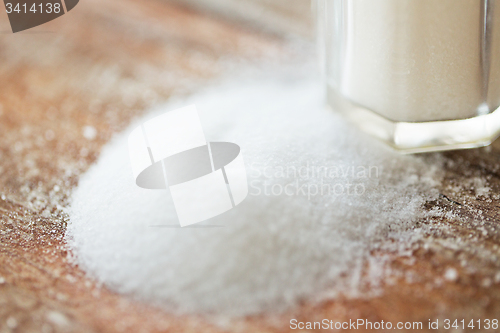 Image of close up of white salt cellar on wooden table