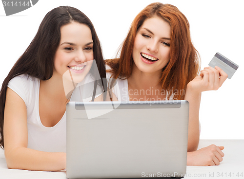 Image of two smiling teenagers with laptop and credit card