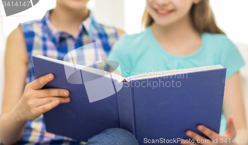 Image of close up of happy girls reading book at home