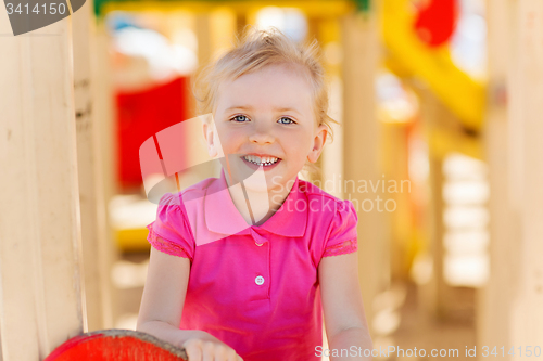 Image of happy little girl climbing on children playground