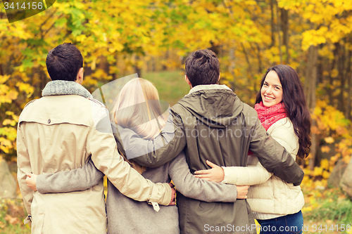 Image of group of smiling men and women in autumn park