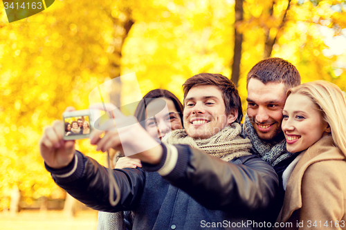 Image of group of smiling men and women making selfie