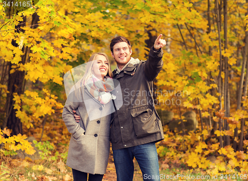 Image of smiling couple hugging in autumn park