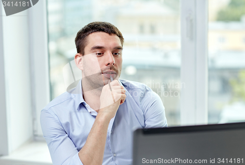 Image of young businessman with laptop computer at office