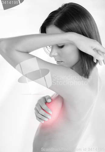Image of woman checking breast for signs of cancer