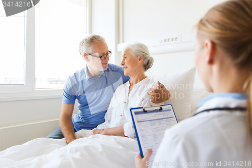 Image of senior woman and doctor with clipboard at hospital