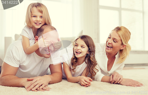 Image of parents and two girls lying on floor at home