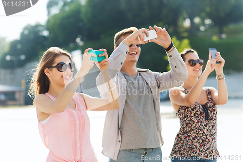 Image of smiling friends with smartphone taking picture