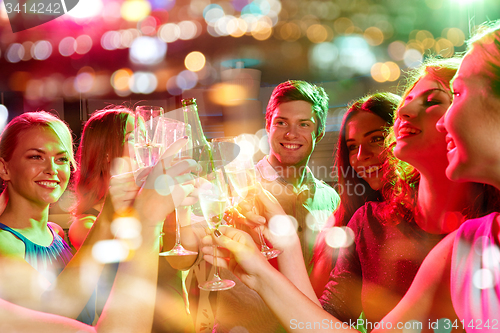 Image of smiling friends with wine glasses and beer in club