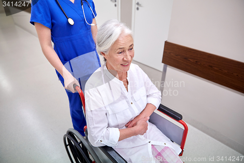 Image of nurse with senior woman in wheelchair at hospital