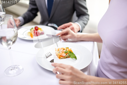 Image of close up of couple eating appetizers at restaurant