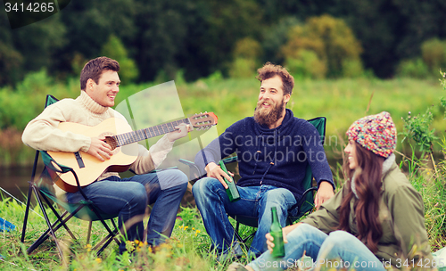 Image of group of tourists playing guitar in camping