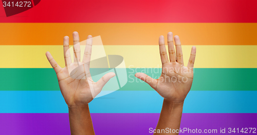 Image of palms of human hands thumbs up over rainbow