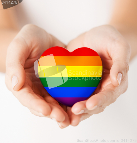 Image of female hands with small rainbow heart