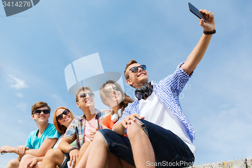 Image of happy friends with smartphone taking selfie