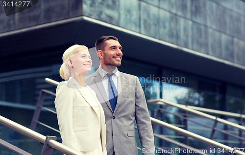 Image of smiling businessmen standing over office building