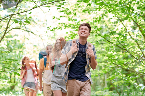 Image of group of smiling friends with backpacks hiking