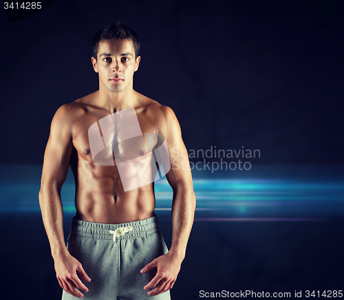 Image of young male bodybuilder with bare muscular torso