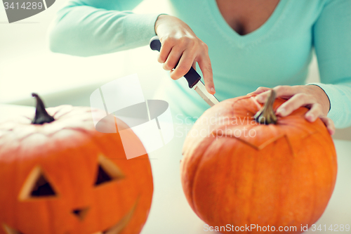 Image of close up of woman with pumpkins at home