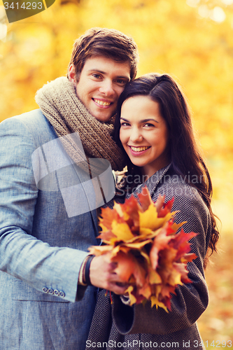 Image of smiling couple hugging in autumn park