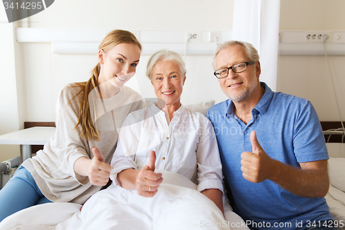 Image of happy family visiting senior woman at hospital