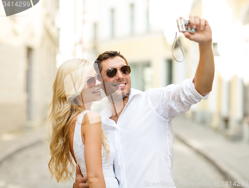 Image of travelling couple taking photo picture with camera