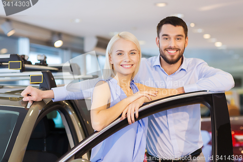 Image of happy couple buying car in auto show or salon