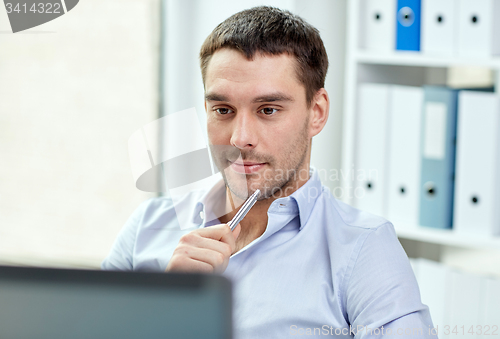 Image of young businessman with laptop computer at office